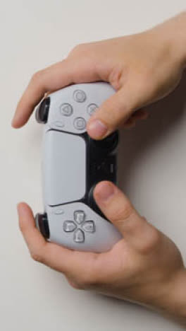 Vertical-Video-Overhead-Studio-Hands-Playing-Sony-PlayStation-Video-Game-Controller